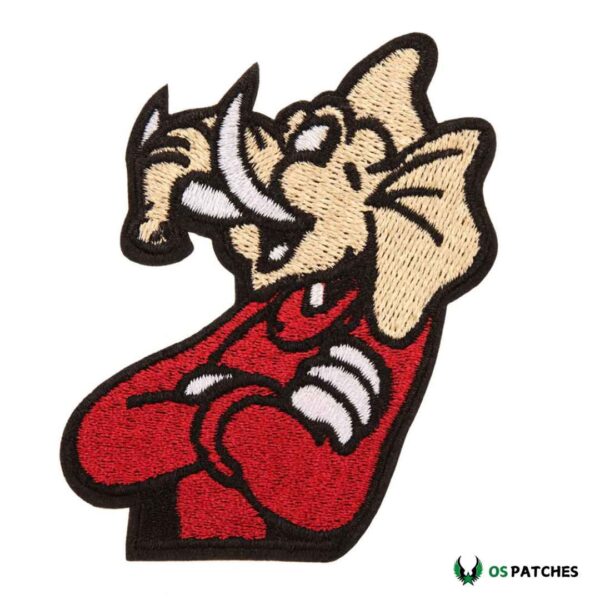 Cartoon-style elephant embroidered patch with tusks, red shirt, and crossed arms.