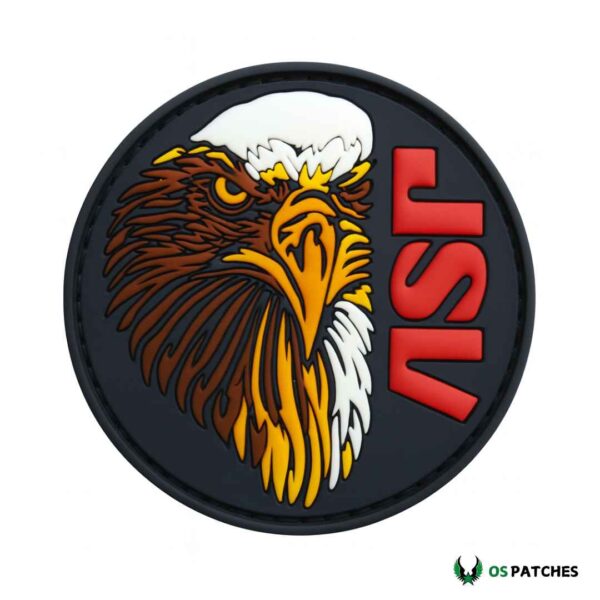 Round PVC patch with fierce eagle head design and bold red letters “JSV.”