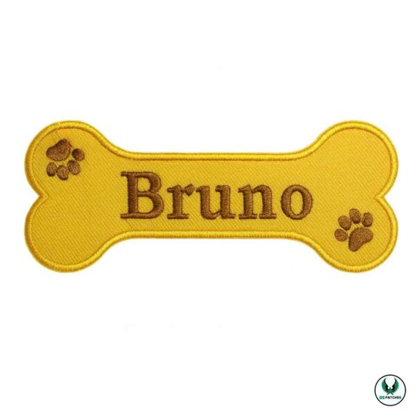 Yellow bone-shaped embroidered patch with brown text Bruno and paw prints
