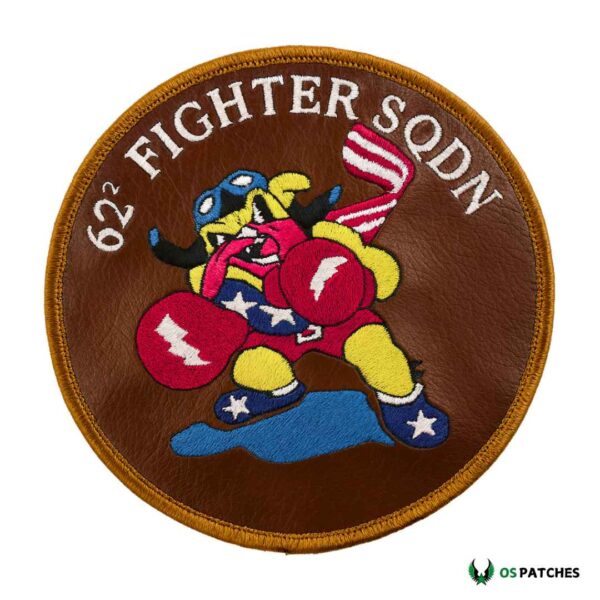Round brown leather patch with embroidered cartoon boxer character, American flag, and text “62 FIGHTER SQDN.”