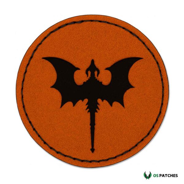 Round orange leather patch with black embroidered dragon silhouette and wings.