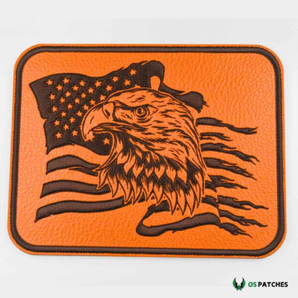 Rectangular orange leather patch with embroidered bald eagle head and waving American flag design.