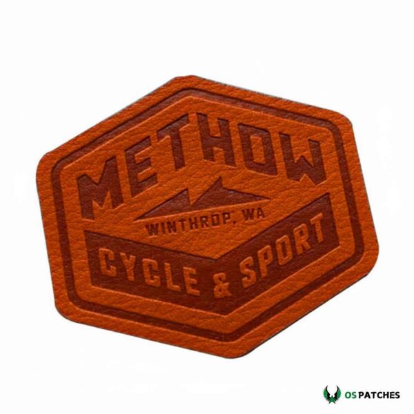 Hexagon brown leather patch engraved with Methow Cycle & Sport Winthrop WA logo