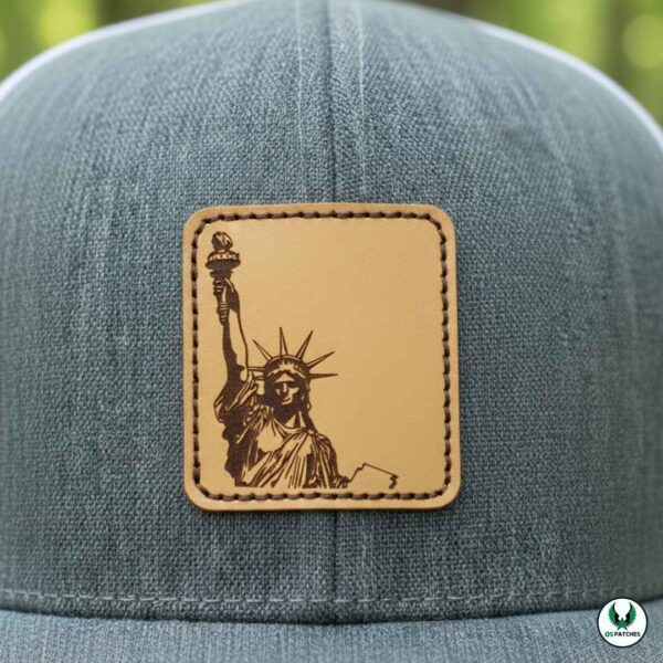 Gray cap with engraved leather patch featuring Statue of Liberty design