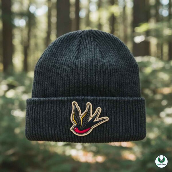 Black knit beanie with embroidered swallow bird patch