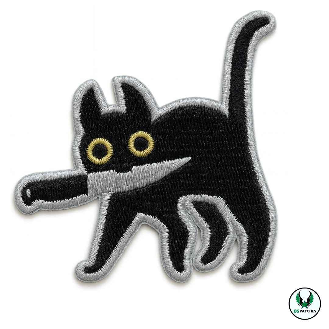 Black embroidered cat patch holding a knife in its mouth